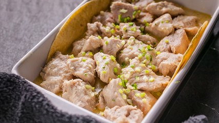 Close up Stewed white meat of turkey in a creamy sauce with herbs and seasonings in a ceramic bowl