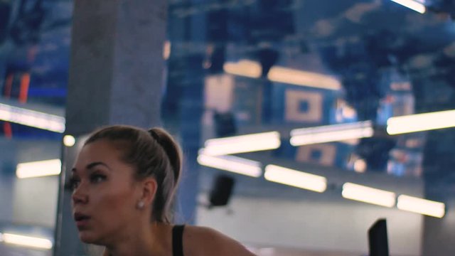 Young woman working out in gym. Performing hyperextensions on back extension machine.
