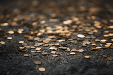 Texture of gold coins on a grey stone. Finance, economy, money of tourists from different countries