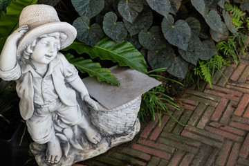 Obraz premium Green garden decorated with little boy doll