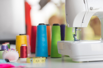 The white sewing machine and needlework equipment on the table