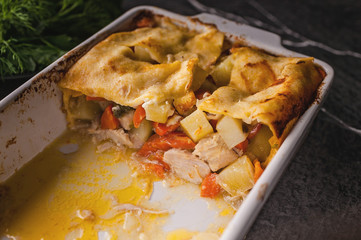 Potato casserole with meat and vegetables, parsley, dill and sauce. Tasty and healthy food.