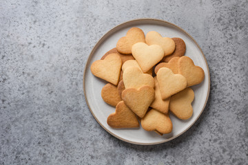 Valentines day greeting card with heart shaped cookies and coffee cup on grey stone table.