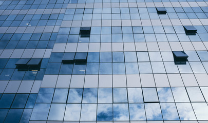 View of blue windows in a skyscraper modern offices building -  concept of people at work at life - openand close windows with sky reflection