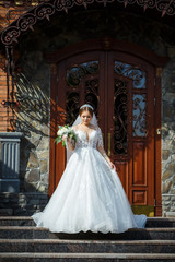 bride in a white dress with a bouquet in her hands and a crown on her head