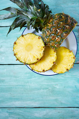 Fototapeta na wymiar fresh pineapple on turquoise wooden surface