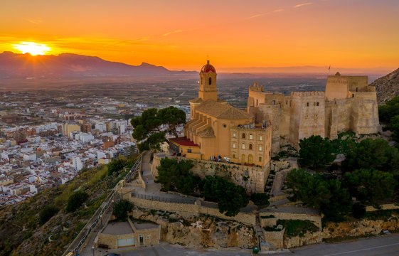 Aerial sunset view of Cullera castle and Sanctuary of the Virgen del Castillo above the popular summer resort vacation beach town near Valencia Spain