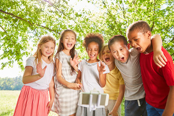Children as friends wave for a self portrait