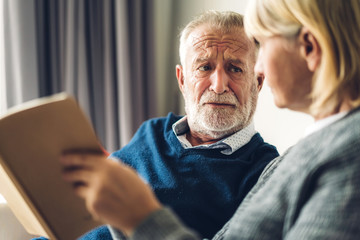 Senior couple relaxing and talking together sitting on sofa in living room at home.Retirement couple concept