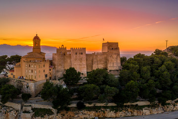 Aerial sunset view of Cullera castle and Sanctuary of the Virgen del Castillo above the popular summer resort vacation beach town near Valencia Spain