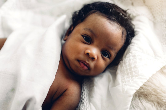 Portrait of cute adorable little african american baby sleep in a white bedroom