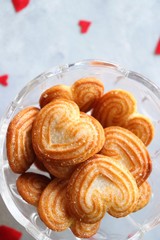 Love food - Hearts shaped biscuits for Valentines day. Sugar cookies in shape of heart top view along with artificial red hearts. Valentines day greeting card with copy space.