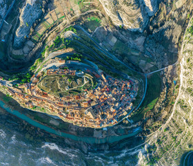 Aerial top down view of the Jucar river surrounding the medieval hilltop town of Jorquera in Spain 