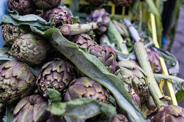 Roman artichokes on the market stalls. Chopped artichoke plants. Cuisine with artichokes, traditional Italian cuisine.