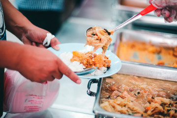 The hands of the poor are waiting to receive food from the rich, compassionate, free food donations to the homeless