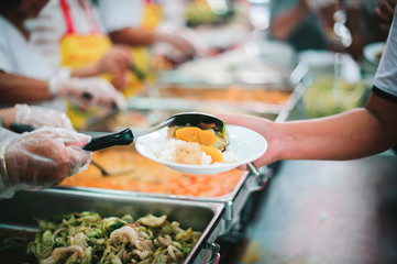 People holding a plate receiving a donation from a good friend, the concept of giving with care