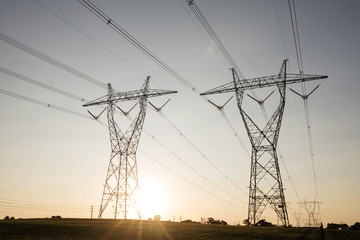 landscape of powerlines with sunset in background.