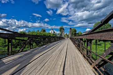 Summer landscape with chain cable-stayed bridge and  St. Nicholas Church (Ostrov, Pskov oblast, Russia)