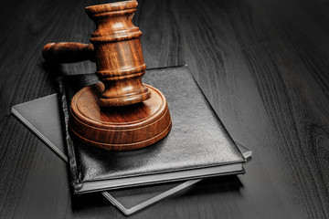 Wooden mallet on black wooden table close up