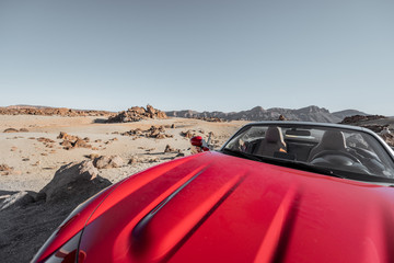 Convertible car on the roadside of the desert valley, traveling by car concept
