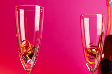 Champagne glasses with party tinsel on bright background