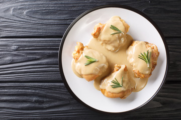 Tasty chicken thighs baked with Dijon mustard and maple syrup close-up in a plate. Horizontal top view