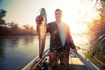 Young amateur angler holds the Wels catfish