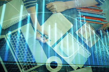 Financial chart drawn over hands taking notes background. Concept of research. Double exposure