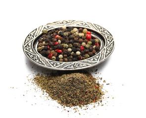 Peppercorns with milled pile in embroidered, embossed decorative pot, bowl isolated on white...