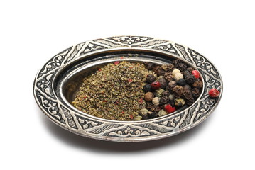 Peppercorns with milled pile in embroidered, embossed decorative pot, bowl isolated on white...