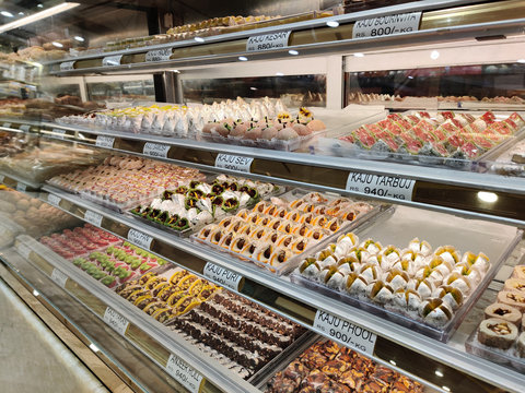 traditional Indian sweets kept in the fridge of a decorated mithai shop. Desserts like Laddoo, Barfi, and other dry fruits like cashew are gifted in festivals and weddings are on display