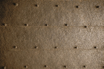 Textured metal rusty surface with bolt caps.