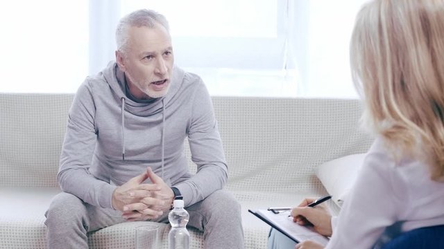 mature sportsman talking and gesturing while talking to psychologist