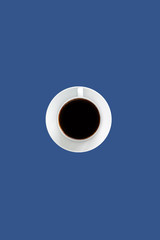 Black coffee espresso in white cup and saucer, blue color background with empty space for text, unhealthy food concept  