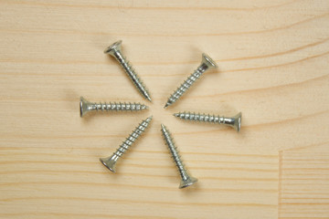 screws and screwdriver on wooden background