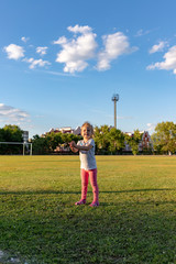 A small child goes in for sports in the stadium. hanging on the horizontal bar, on the uneven bars