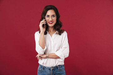 Woman in glasses talking by mobile phone.