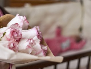 Fototapeta na wymiar White and pink roses on the background of a newborn baby girl