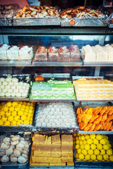 Showcase with a variety of sweets on the street in Asia. Confectionery on the counter, close-up.