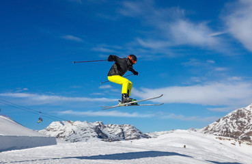 Fototapeta na wymiar Skier jumps in snow park against the blue sky