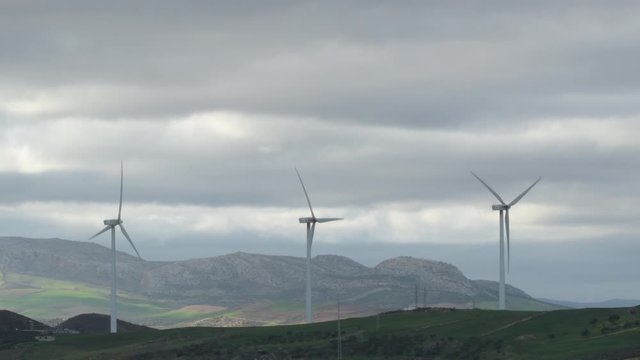 Wind turbines of renewable energy moving a cloudy day