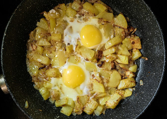 the fresh eggs and potatoes are fried in a pan
