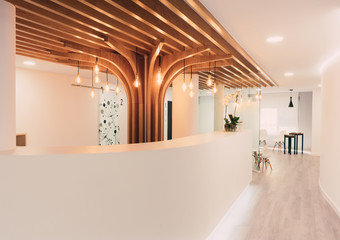 Reception of modern office with lights and wood on the ceiling