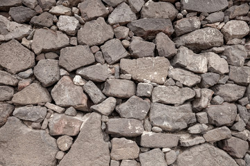 Old grey stone wall made from volcanic stone.