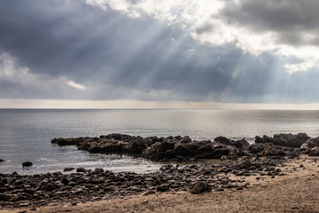 sunset or sunrise on the beach with rock and sun beam 