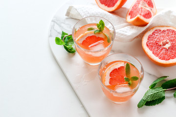 Healthy grapefruit drink with mint on a white background with a copy space