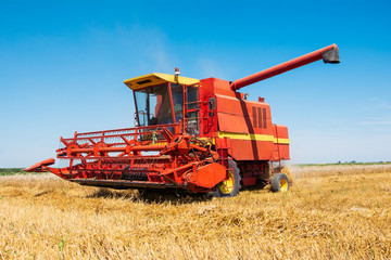 Combine harvesting in a field of golden wheat.
