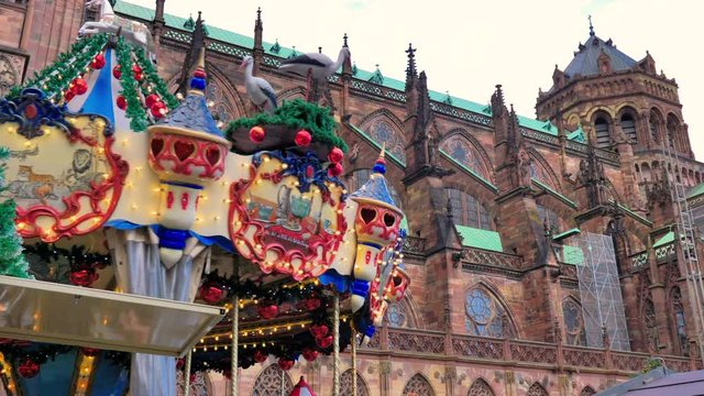 Tiovivo de colores girando junto a catedral Estrasburgo en atardecer de navidad