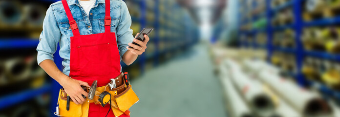 Smiling young man working in a warehouse standing with a bag of product over his shoulder grinning happily at the camera, close up view