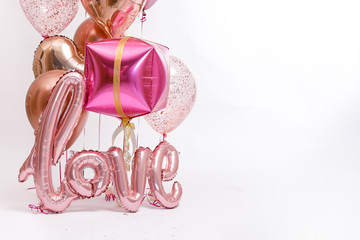 Stylish metallic pink balloons for Valentine's day, hen party or baby shower on a white background. The inscription "Love".